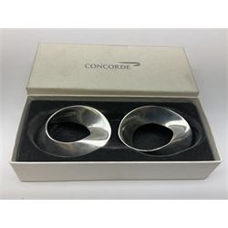 Concord silver port label, British Airways, Birmingham 1998, together with a pair of Concord Stainless steel serviette rings, of stylized form, both in original boxes