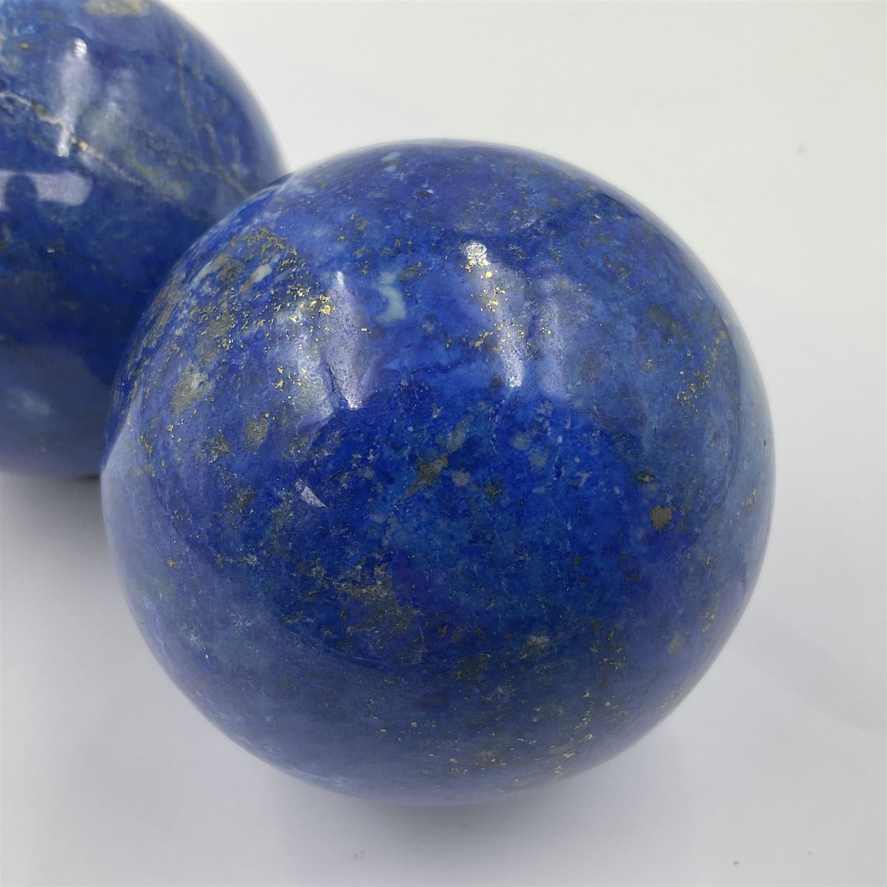 Pair of Lapis lazuli spheres, upon a carved stone stands, D8cm