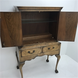 Georgian style walnut cocktail cabinet on stand, two cupboards enclosing glazed shelf above two drawers, cabriole legs on ball and claw feet, W84cm, H137cm, D48cm