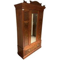 Late Victorian walnut wardrobe, carved arched pediment, fitted with single bevelled mirror door, flanked by carved and figured panels, enclosing hanging rail and hooks, single drawer fitted to base