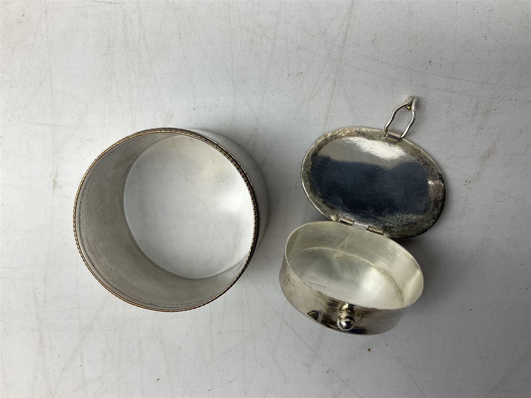 French silver plated wine taster of typical form, stamped, together with a silver plated napkin ring, and an 'Alpaca Silver' pill box with mother of pearl detailed cover, (3)