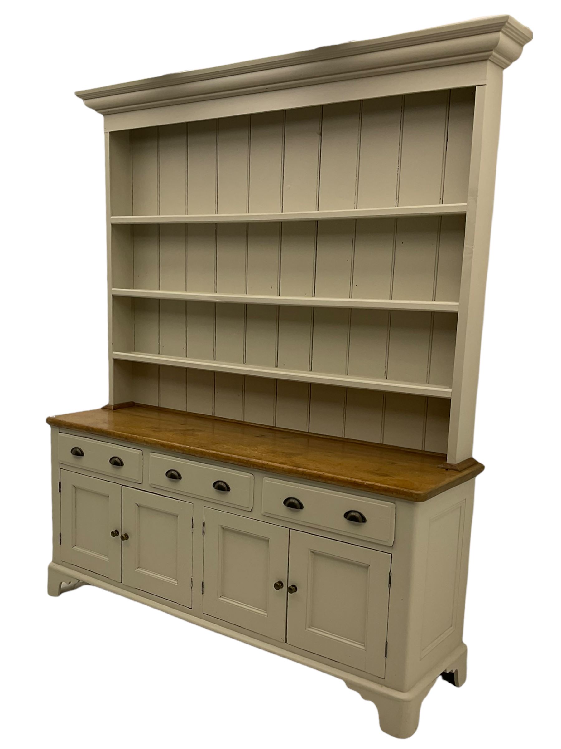 Victorian pine dresser, raised painted three heights plate rack with projecting cornice, waxed top over pained base fitted with three drawers and two double cupboards, bracket feet