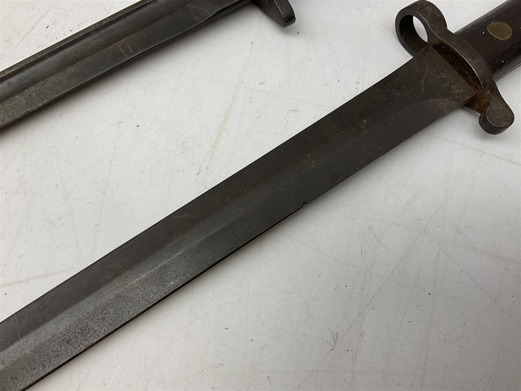 British Pattern 1907 bayonet with 43.5cm fullered steel blade; in leather scabbard with webbing frog L58cm overall; another Pattern 1907 bayonet lacking scabbard; and British Pattern 1888 Mk.I bayonet by Wilkinson London (no scabbard) (3)