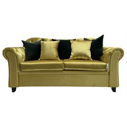Chesterfield shaped two seat sofa, upholstered in buttoned gold fabric, with scatter cushions