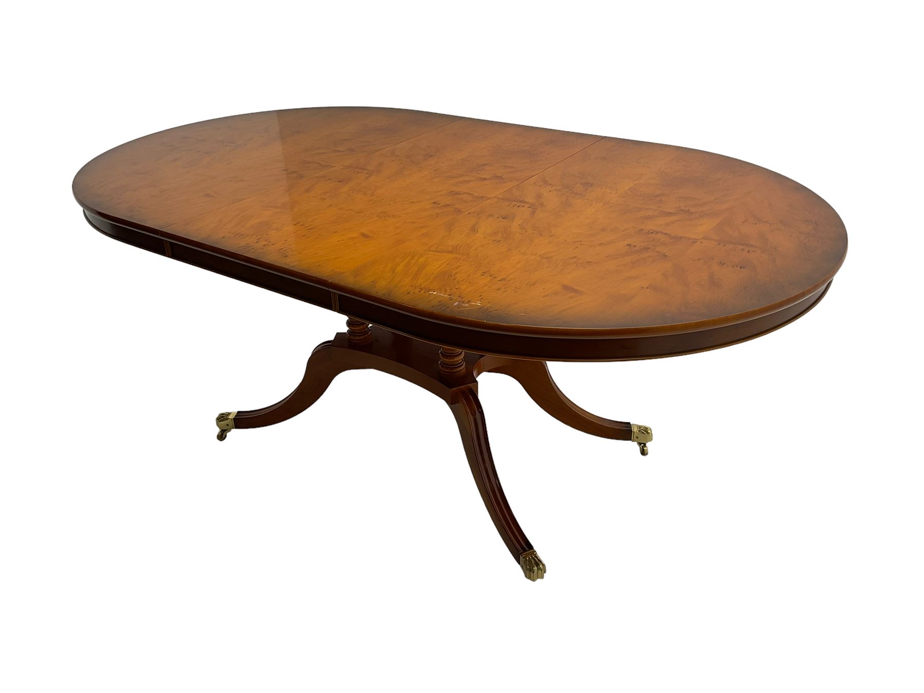 Georgian design yew wood twin pedestal dining table, circular top over four turned columns joined by base, raised on splayed and fluted cabriole supports with paw feet and castors (140cm x 108cm x 77cm); with set six (4+2) Georgian style yew wood dining chairs, middle rail pierced and carved with flowerhead and extending foliage, upholstered drop in seat, raised on turned tapering supports (50cm x 47cm x 86cm)