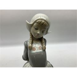 Two Lladro figures, Dutch Girl with Braids no 5063 and Dutch Girl Kristina no 5062 together with two Lladro Gres figures Fernando no 12167 and Julio no 12168, two with original boxes, largest example H25cm