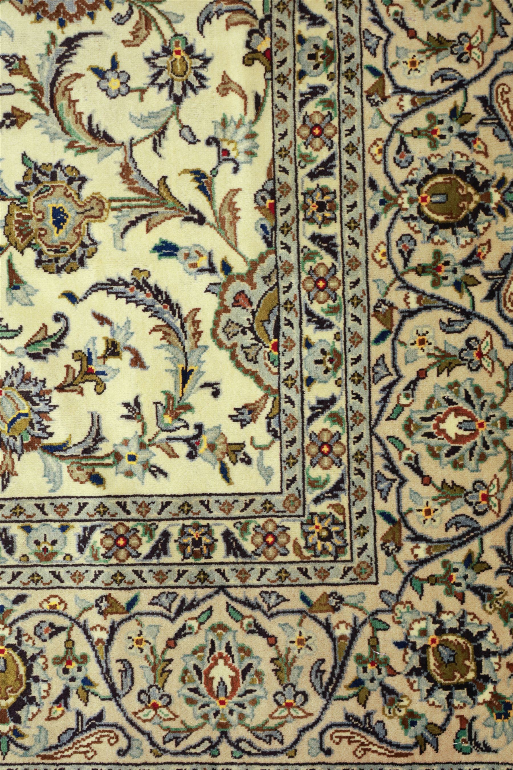 Central Persian Kashan carpet, ivory ground, field with an all-over design of scrolling palmettes and floral sprays in blue and terracotta within a beige ground and pale blue floral border