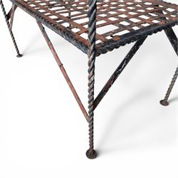 Victorian design wrought iron garden bench, with asymmetrical rope-twist frame, arched back and sides over out-swept arm terminals with ball finials, flanking a lattice seat, in antique black-painted weathered finish