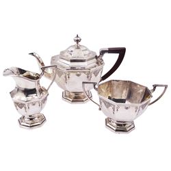 1920's silver three piece tea service, comprising teapot with wooden handle, twin handled sucrier, and milk jug, each of octagonal form with engraved decoration, upon an octagonal stepped foot, hallmarked Mappin & Webb Ltd, Sheffield 1927, teapot H18cm, approximate gross weight 39.95 ozt (1242.7 grams)