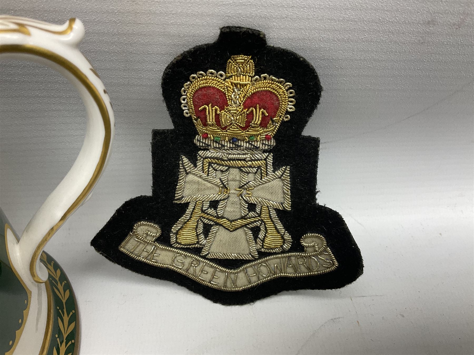 Limited edition Spode Green Howard's twin handled loving mug, no 205/300, with certificates, together with a Green Howards cased Tercentenary medal (1688-1988), cap badge and embroidered patch, largest H11.5cm