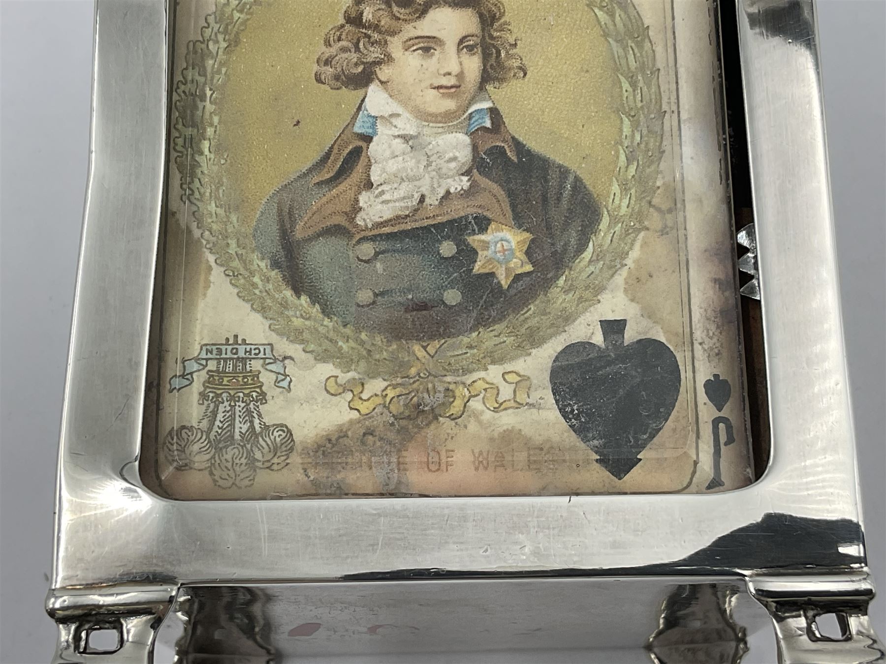 Edwardian silver mounted playing card case, hallmarked William Harrison Walter, Birmingham 1903, the sides each with a period playing card set behind a bevelled glass panel, the hinged cover with later engraving 'Presented to Norman T Crombie Esq by the officers & men of the 31st WR Detachment for services rendered 1917-1918', with red leather lined interior, the three compartments upon a sprung base and containing two later wooden Whist markers, case H12.5cm