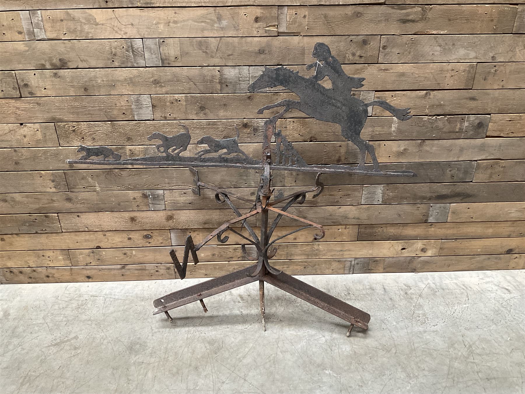 Black painted wrought iron weather-vane depicting hunting scene and compass points
