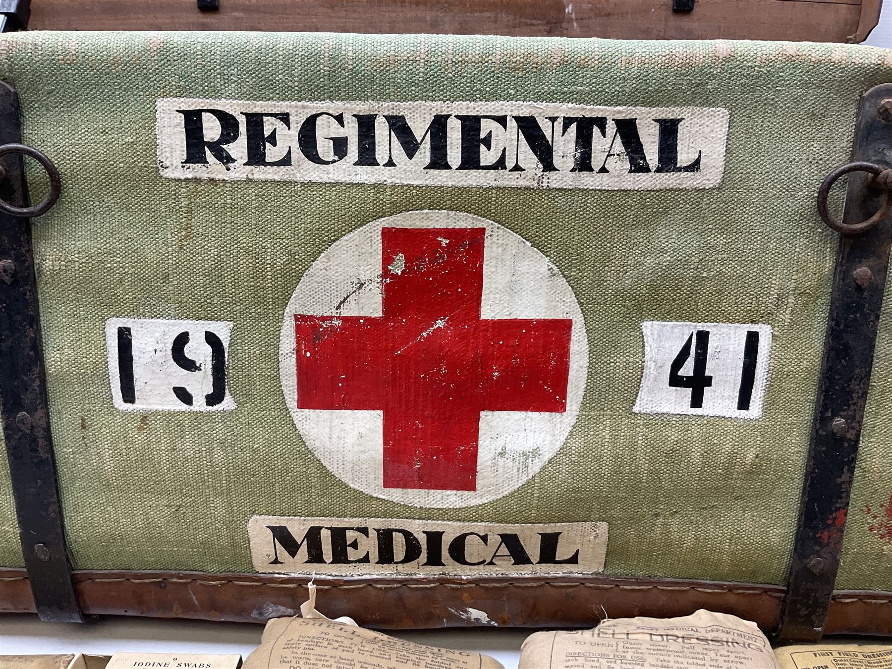 WW2 British Army RAMC 'Regimental Medical Pannier', well marked externally and dated 1941, stamped May 1943 internally, canvas covered wicker form with leather edges, hinged top and fall front with two rope carrying handles, fitted iron locking straps with securing chains; contains various unused field dressings and bandages with WW2 dates and two pillows; original label under lid L79cm