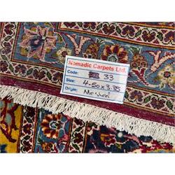 Central Persian Kashan hand-knotted carpet, madder red field with an intricate design of scrolling vines, palmettes, and rosettes with a central lobbed medallion with pendant motifs in shades of blue and ivory, and spandrels all within a blue-ground border of palmettes and flowerheads between multiple guard borders, 450cm x 335cm 