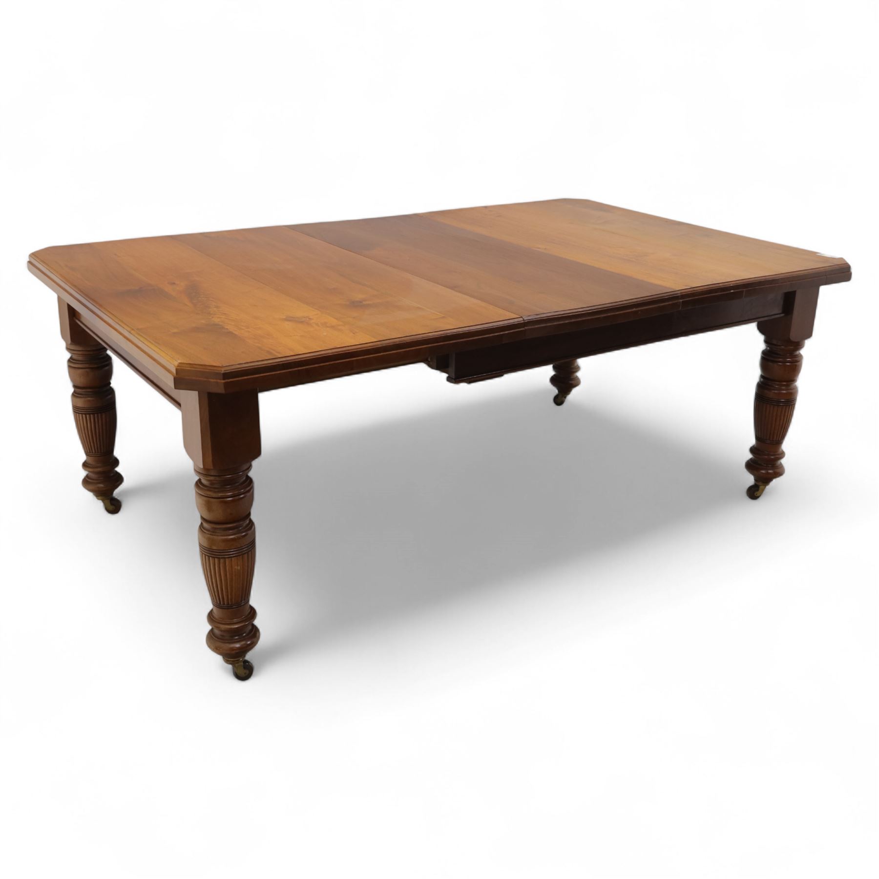 Victorian mahogany extending dining table, rectangular top with chamfered corners above a plain frieze raised on turned reeded legs with castors and two additional leaves, 197cm fully extended, and a set of six early 20th century oak upholstered chairs with drop-in seats, arched panelled back splat and close studded border on turned front legs joined by stretchers, 47x41x109cm 