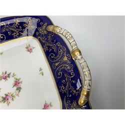 Coalport ten plates and four small serving platters, decorated with floral sprigs within a cobalt blue border, and heightened in gilt with C scrolls and foliate detail