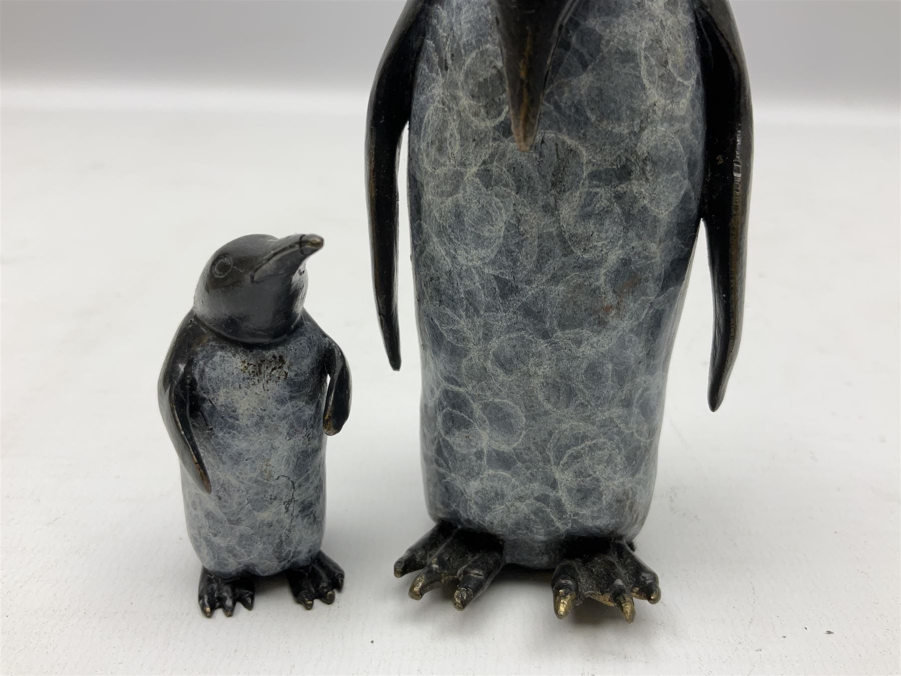 Steve Boss (British 1970-); Bronze figure group of a family of Emperor penguins, entitled Waddle, all with artists monogram beneath, tallest H12cm