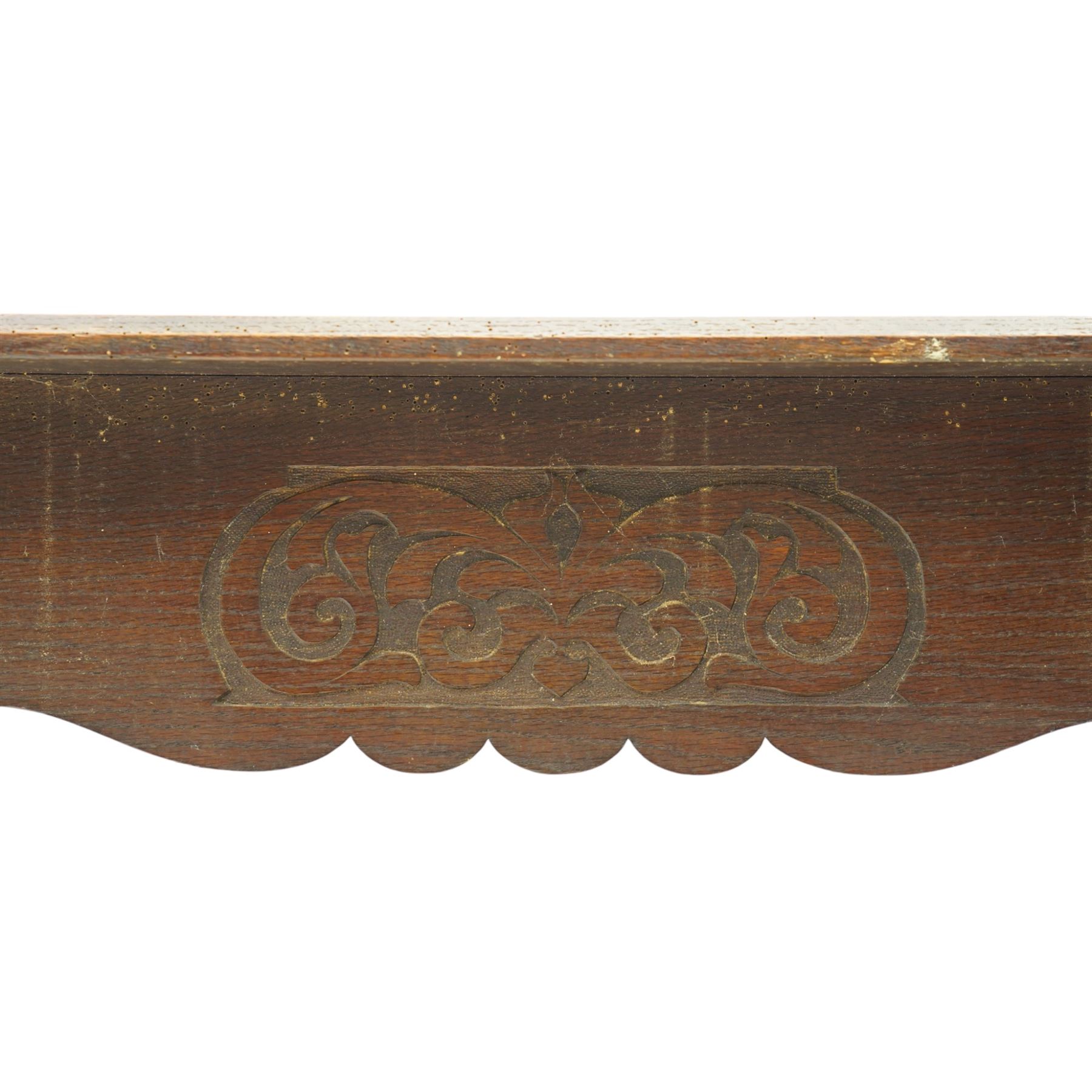 Arts and Crafts oak table, the rectangular top decorated with incised and carved scrolling foliage panels, the centre carved with a shield-shaped cartouche dated 1905, over a simple frieze with matching carved decoration to the front, on straight tapering legs