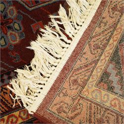 Persian Karabagh design rug, red madder field with three linked octagonal medallions surrounded by floral geometric motifs within multiple stylized borders 