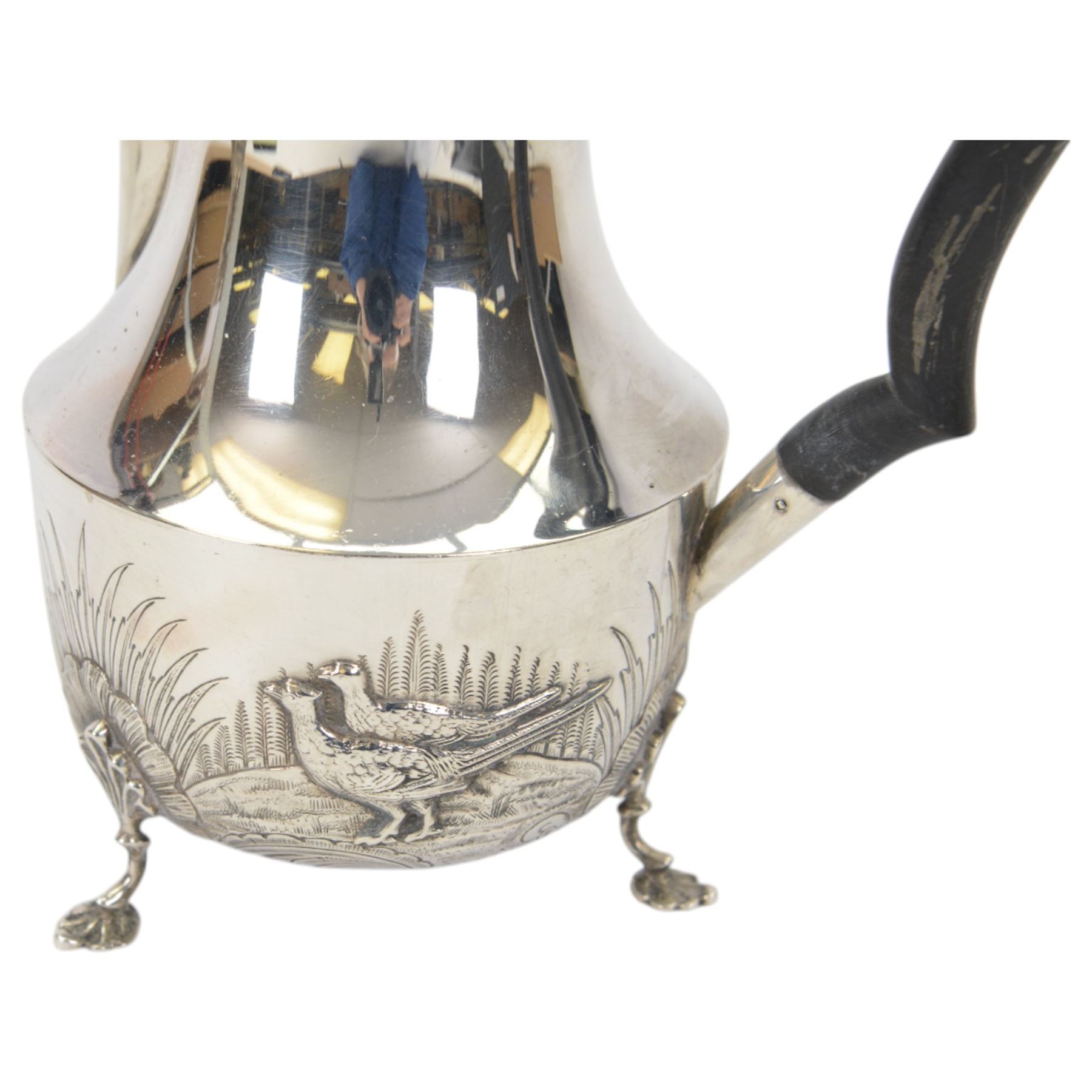 1920s silver hot water pot, with chased and repousse decoration to body depicting pheasants and rabbits in a countryside setting, with Bakelite type handle and finial, upon three palmette mounted feet, hallmarked S Blanckensee & Son Ltd, Birmingham 1928, H22cm