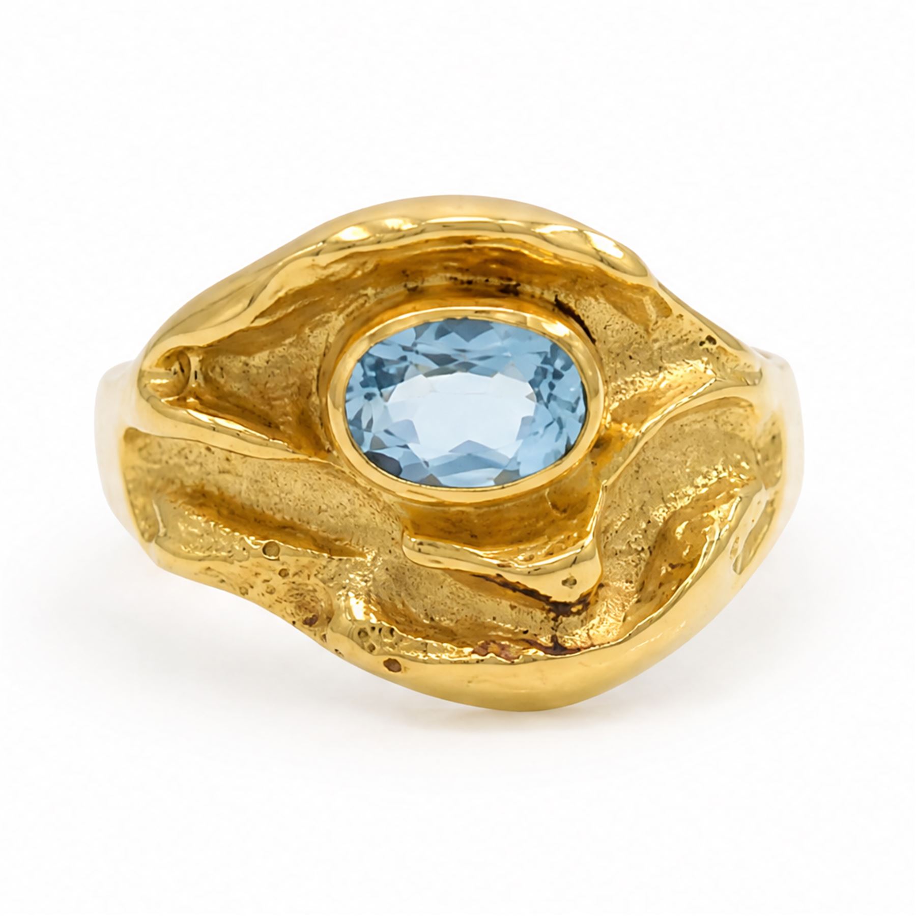 18ct gold Swiss blue topaz ring, bezel single oval cut topaz, within an abstract creased design setting, stamped 750
