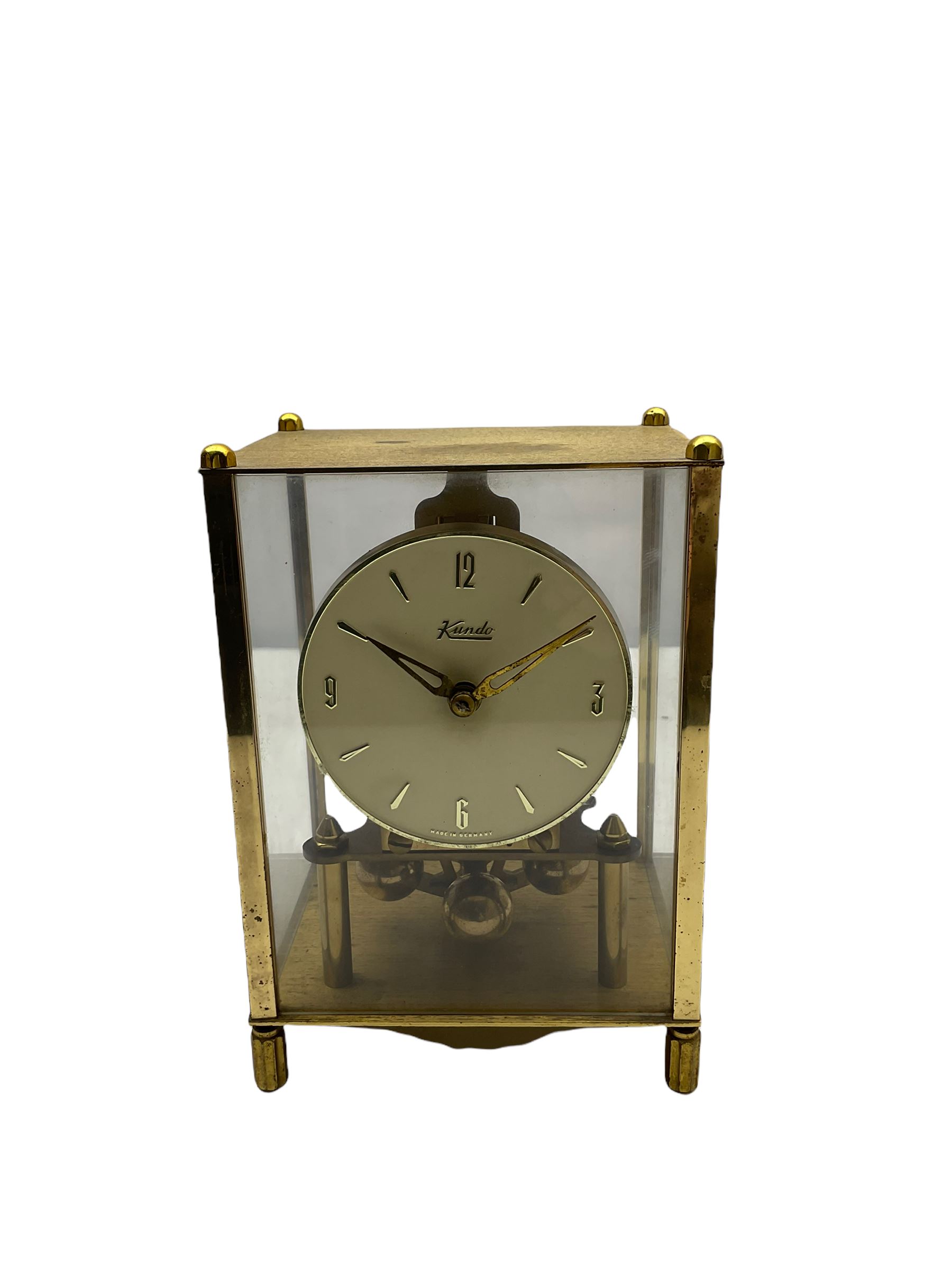A 20th century English Torsion clock marketed by Bentime Ltd, London, with a four-ball rotary pendulum, white dial with gilt Arabic numerals and pierced gilt hands, under a glass dome, base with adjustable feet. No key.
Bentime Ltd did not make clocks but marketed clocks made by other companies such as J D Francis and Perivale.
H17
With a German Kundo torsion clock in a glazed rectangular case with four glass sides, four-ball rotary pendulum, white painted dial with gilt three-hour Arabic numerals and batons, with pierced brass hands. No key.
H15 W11 D9

