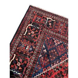 Persian Joshaghan crimson ground rug, stepped lozenge medallion surrounded by repeating foliate lozenge motifs, the border decorated with stylised plant motifs, within geometric guard stripes