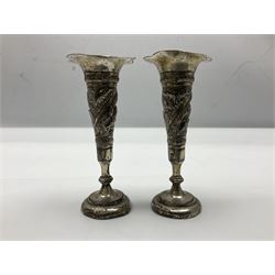 Pair of silver candlesticks, each upon knopped stem and weighted base, hallmarked, together with a pair of white metal vases, repousse decorated with wild animals, upon weighted bases, tallest H13cm