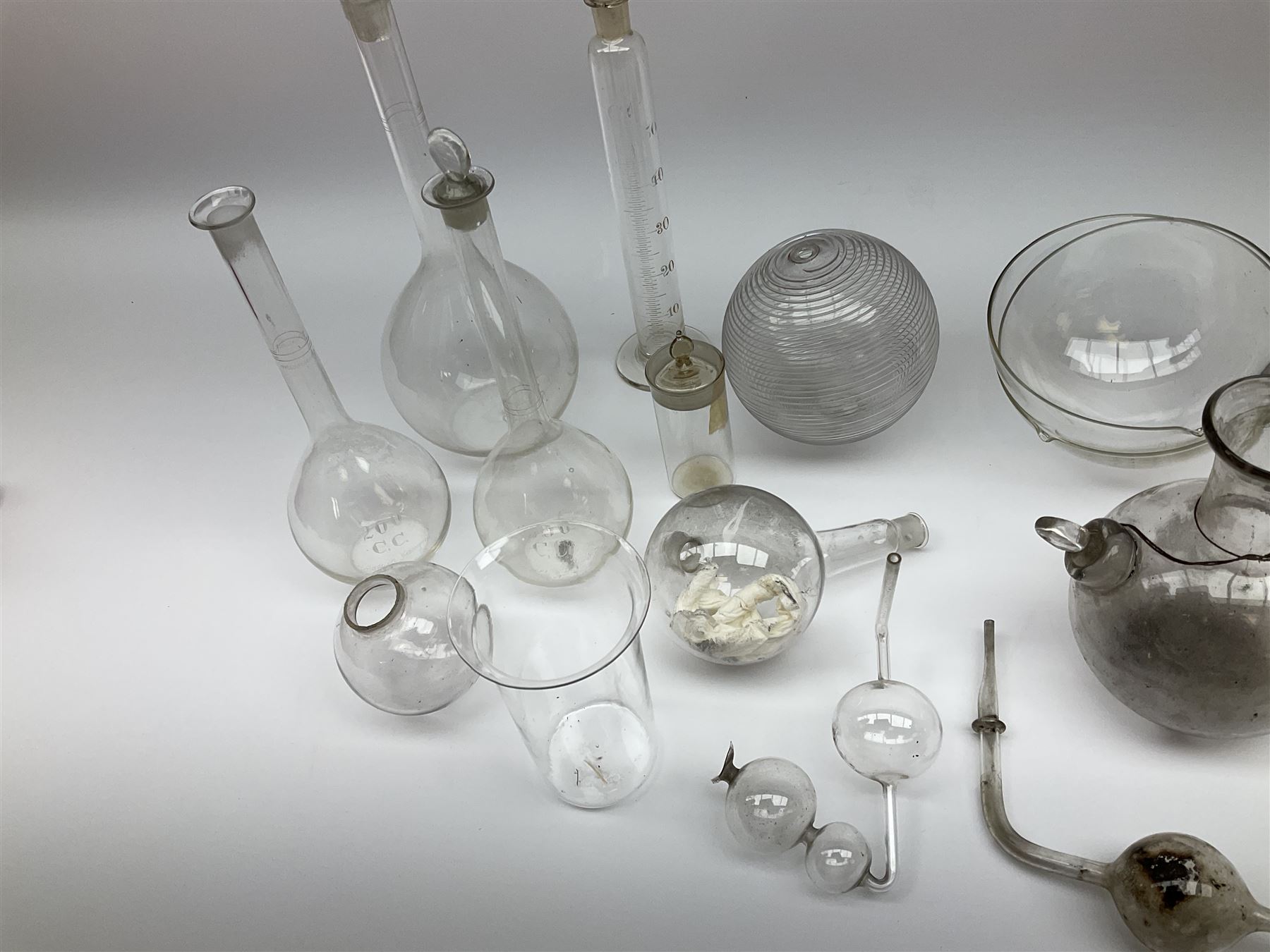 Collection of 19th century and later pharmaceutical laboratory glass, to include, volumetric flasks of various sizes, conical flask, stratus flask, etc (25) Provenance: discovered in the storeroom of a long established Hull pharmacist and opticians