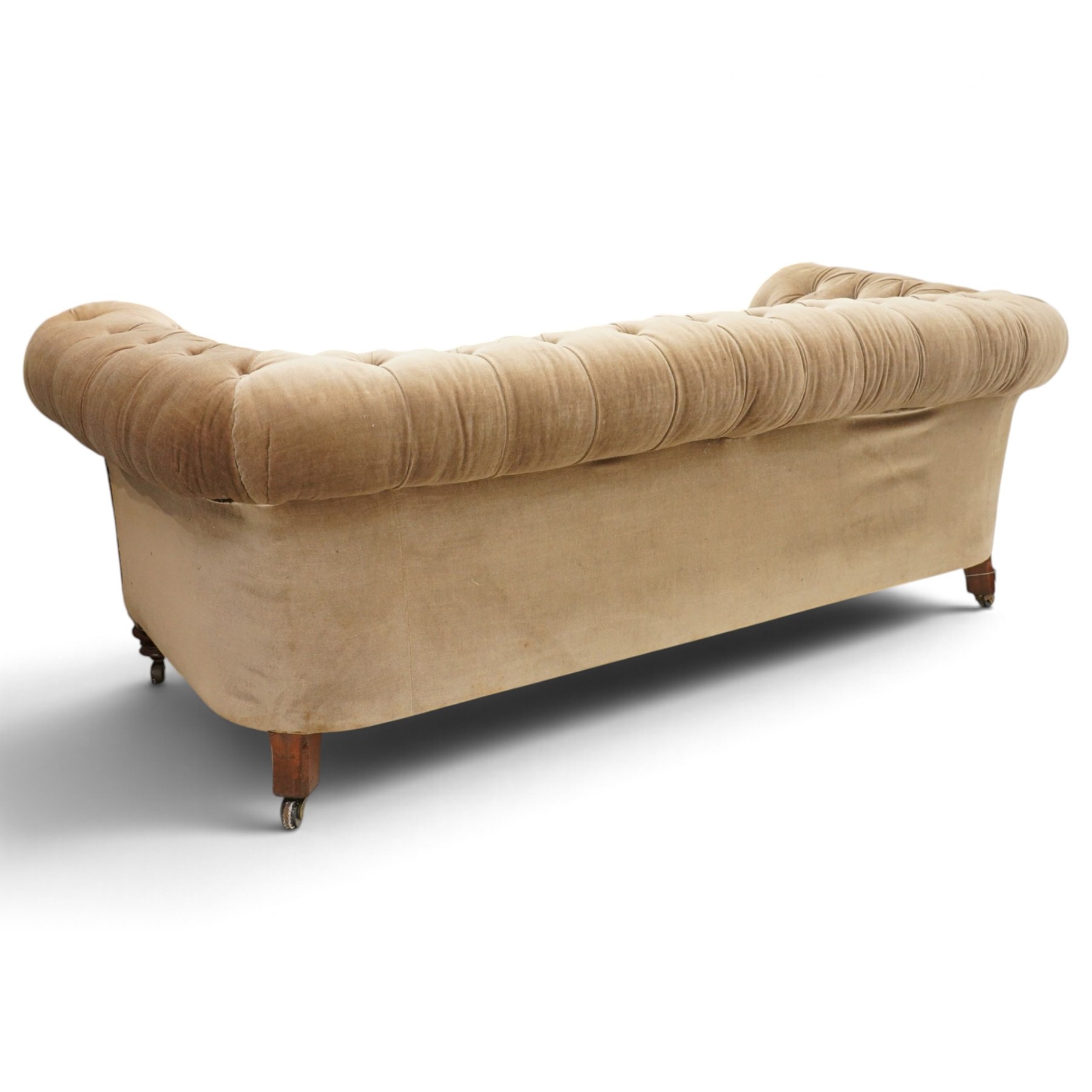 Victorian mahogany framed two seater Chesterfield settee, traditional shape with rolled back and arms over sprung seat, upholstered in buttoned-back neutral fabric, raised on turned front supports with ceramic castors