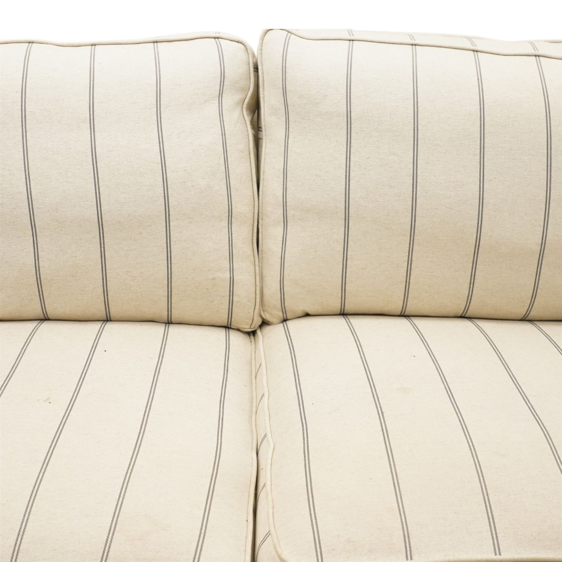 20th century Howard shape two seat sofa, deep seat sofa in cream and grep striped upholstery, raised on dark supports terminating in front castors 