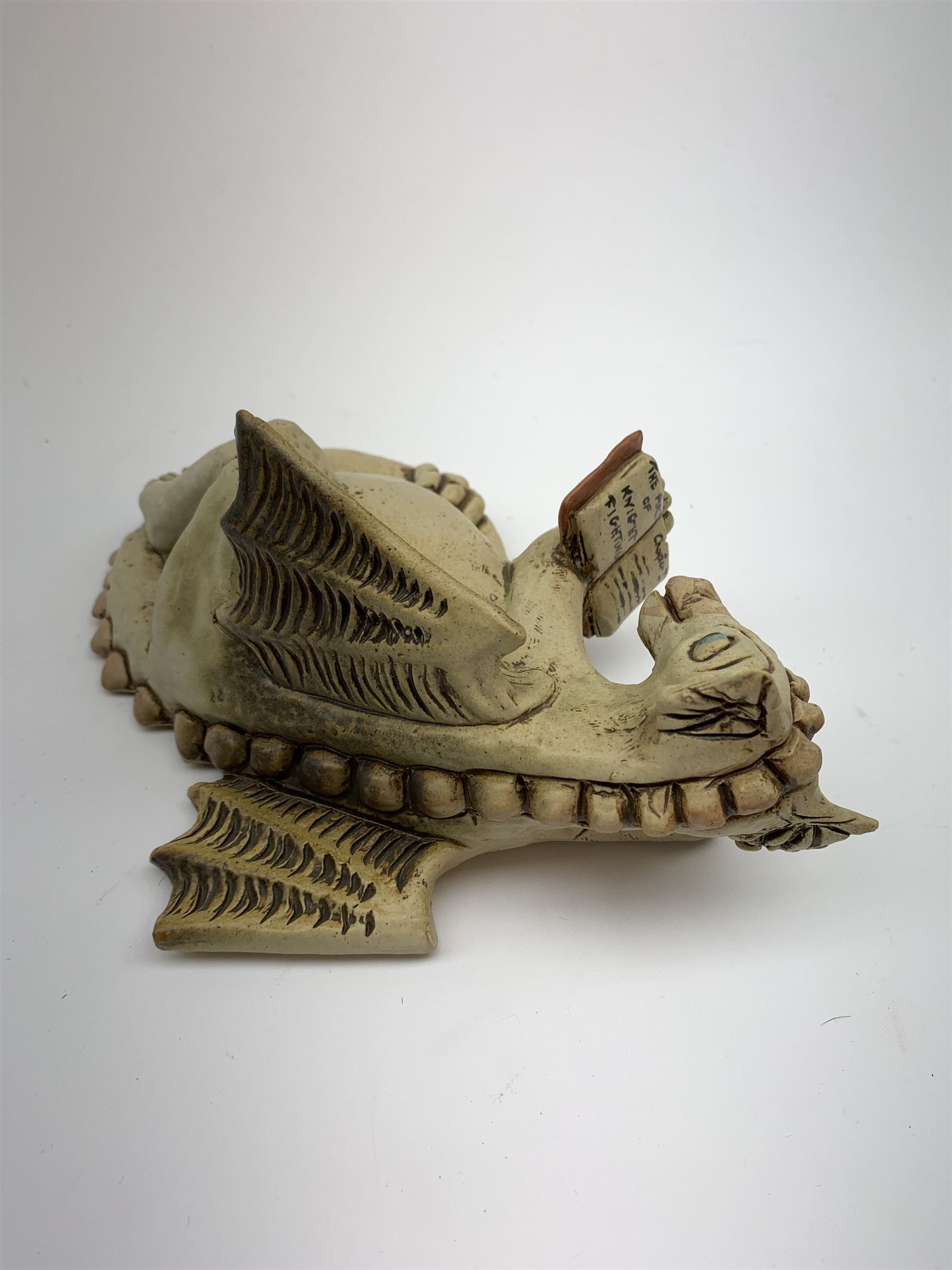Zell Osbourne (British, Contemporary), Bookworm, a Studio Pottery figure modelled as a recumbent dragon with book, L21cm. 