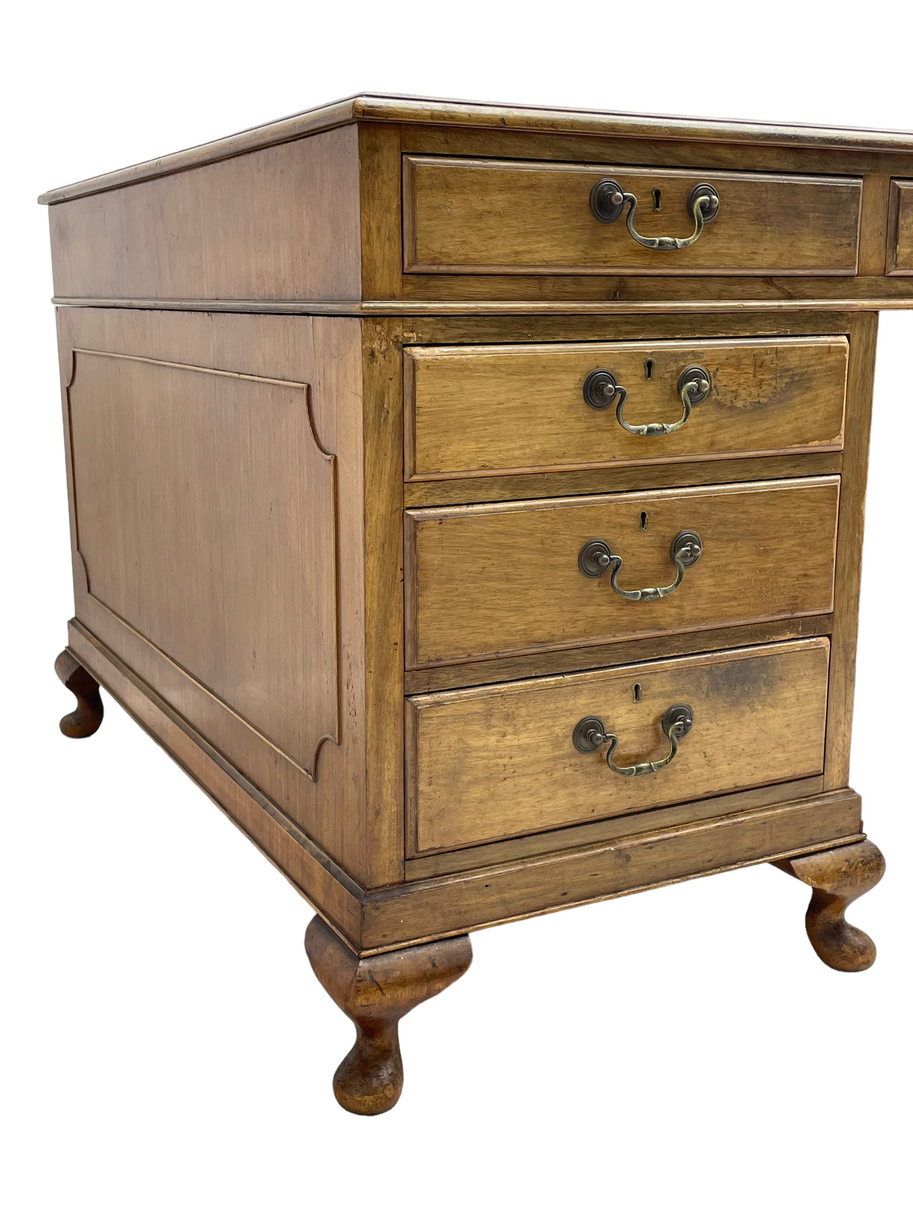 Early 20th century mahogany twin pedestal desk, the moulded rectangular top with three sectional leather insets with gilt decoration, fitted with eight drawers, on cabriole feet