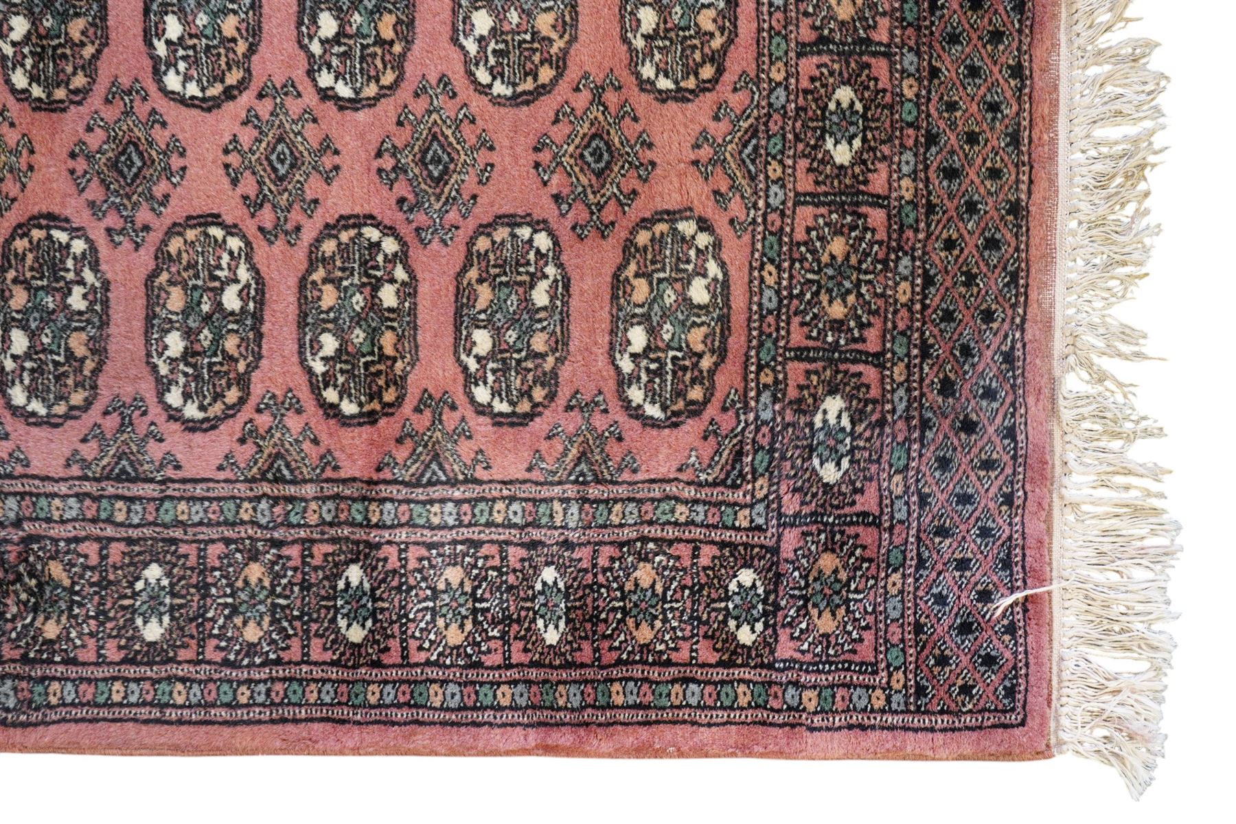 Afghan pale red ground runner, the field decorated with two rows of Gul motifs, within repeating patterned border