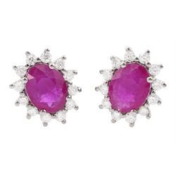 Pair of 18ct white gold oval cut ruby and round brilliant cut diamond cluster stud earrings, stamped 750, total ruby weight approx 2.30 carat, total diamond weight approx 0.50 carat