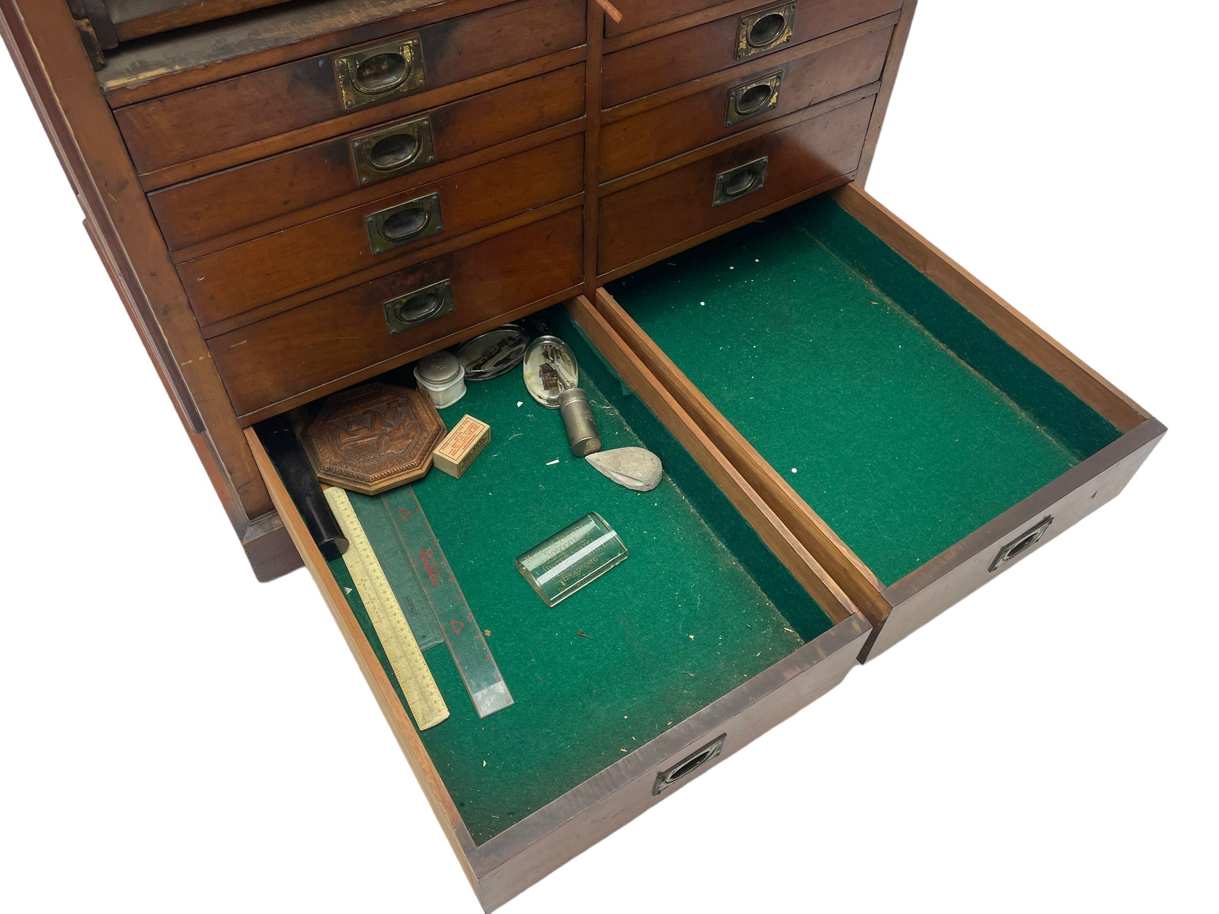 Edwardian mahogany artist's cabinet once belonging to the British artist Eli Marsden Wilson (1877-1965), raised panelled back mounted by carved brackets, sloped and hinged glazed lid enclosing paint holders and compartments, up-and-over panelled door revealing three slides, fitted with two banks of five graduating drawers with recessed brass handles, on skirted base.

Together with a quantity of artists' equipment and tools including paints, paintbrushes, charcoal, chalks, etc. and various prints relating to the life of the artist, including Quaker anti-war posters, Victorian Stevengraphs, and various chromolithographs 

Provenance: Removed from the studio of Eli Marsden Wilson. The cabinet comes to us for sale through family descent. The vendor is descendant of Marsden. Many further etchings removed from the cabinet are being sold in the Spring Art Sale, Friday 15th March 2024, Lots 265-271.

Notes: born in Ossett, Eli Marsden Wilson was the only son of Alfred Wilson, a foreman beamer, and Emma Marsden, and had five sisters. After studying at Wakefield College of Art, he moved to the Royal College of Art in London, where he became a pupil of Sir Frank Short. He had his first exhibit at the Royal Academy in 1905, the same year he married fellow artist Hilda Mary Pemberton.

A Quaker, vegetarian, and pacifist, he was a conscientious objector in World War I and as such was imprisoned in 1917 for two years. In September 1922 he was commissioned by Princess Marie Louise to produce miniature etchings for Queen Mary's Dolls' House at Windsor Castle; two such etchings are being sold in the Spring Art Sale, Friday 15th March 2024, Lot 265.