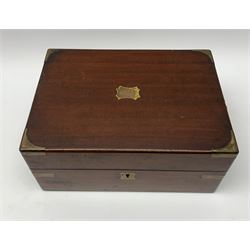 A 19th century mahogany brass bound vanity box, the hinged cover with vacant brass cartouche opening to reveal a fitted interior, with bone handled brushes and glass jars with silver plated covers, L27.5cm D20cm H12.5cm. 