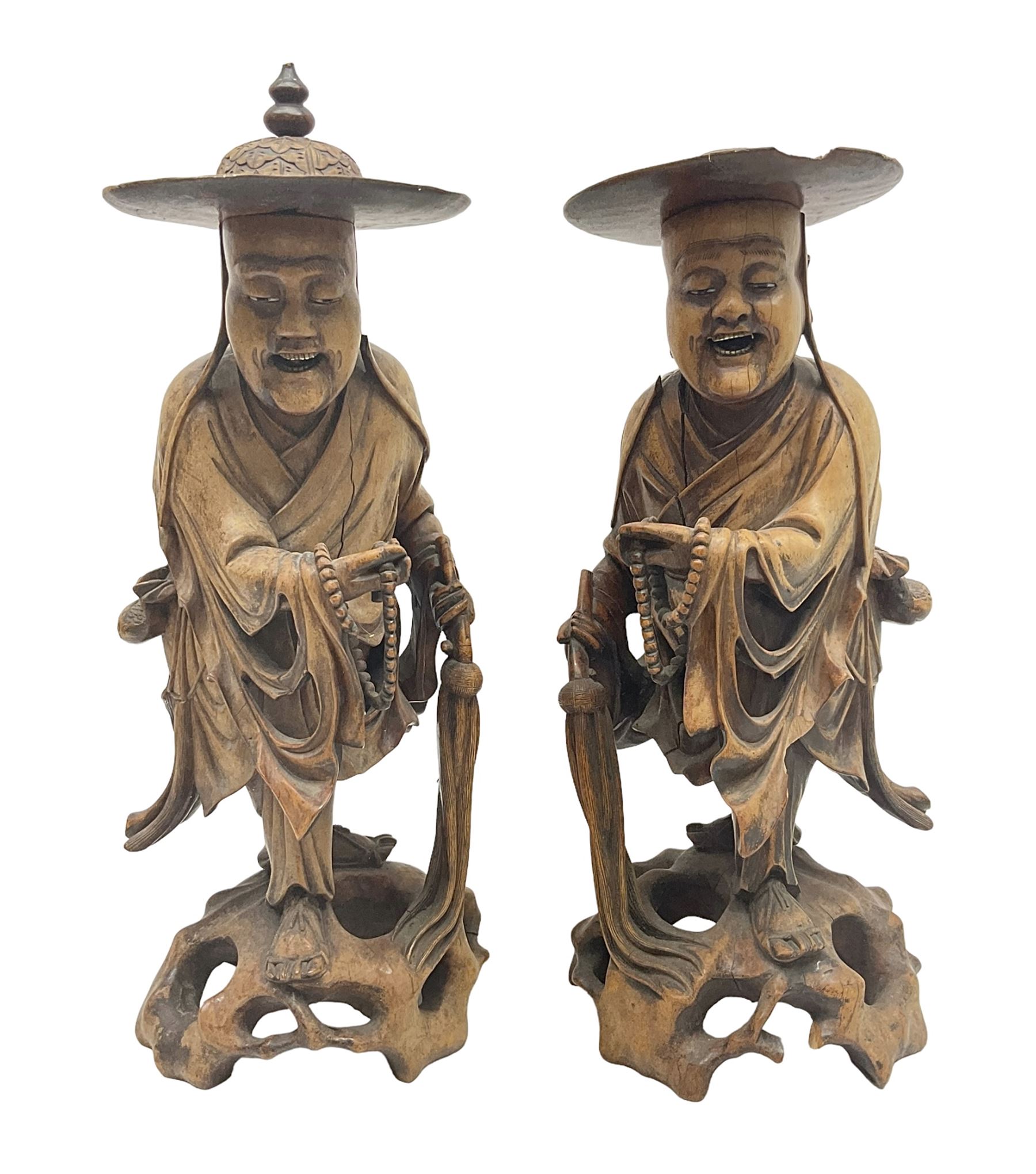 Pair of Japanese carved wooden figures, modelled as merchants in traditional dress, upon pierced naturalistic bases, tallest H39cm