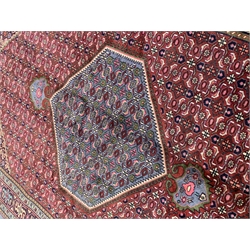Persian Hamadan rug, lozenge red ground field decorated all over with stylised flower head motifs, pole medallion, repeating guarded border, 298cm x 194cm