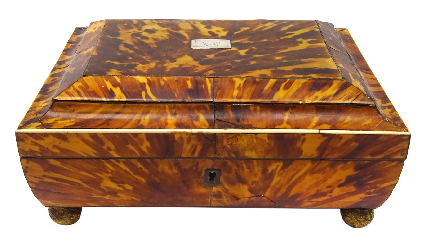 19th century tortoiseshell sewing box, of sarcophagal form upon four foliate detailed brass ball feet, the hinged cover edged in ivory with initialled silver plaque to centre, opening to reveal a silk lined interior, H9.5cm W22.5cm D18cm