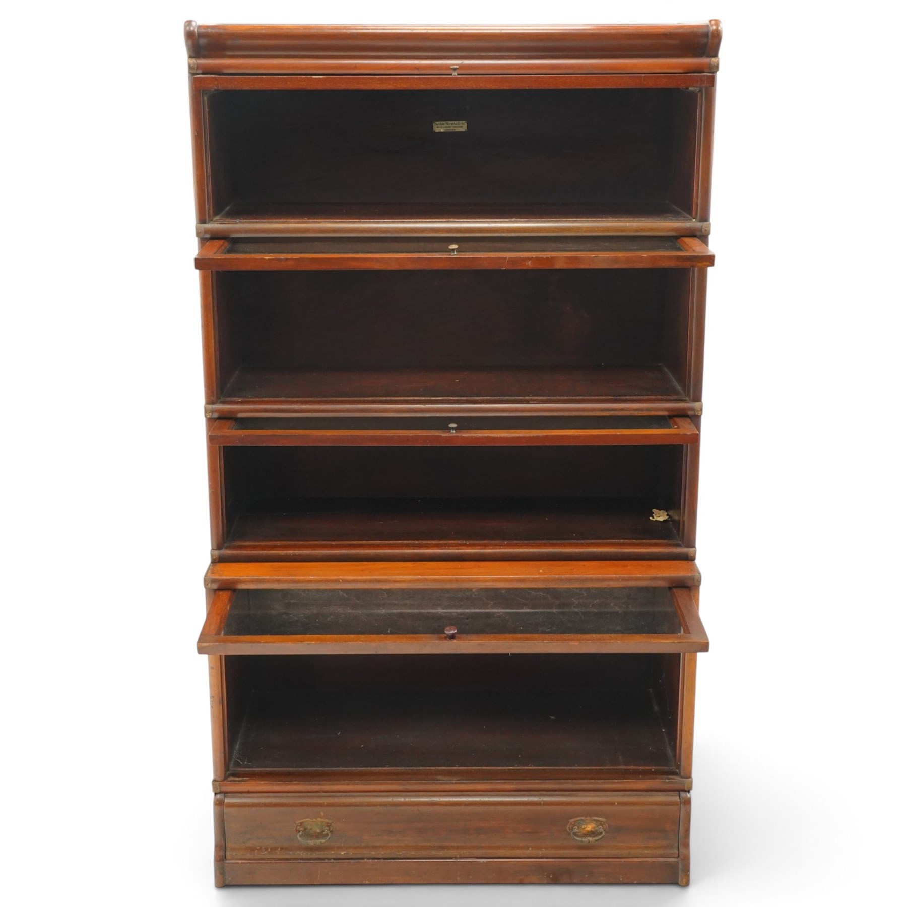 Globe Wernicke - early 20th century mahogany four-tier stacking library bookcase, the shelves fitted with glazed up-and-over doors, fitted with single drawer to the skirted base