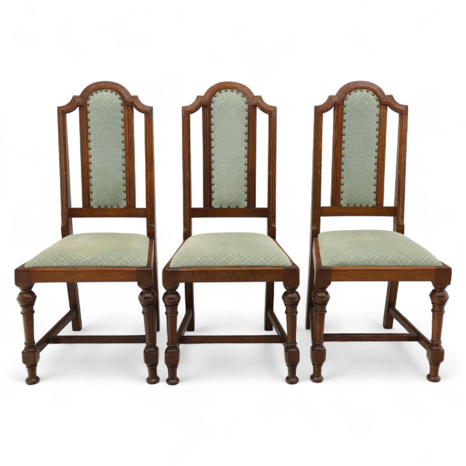 Victorian mahogany extending dining table, rectangular top with chamfered corners above a plain frieze raised on turned reeded legs with castors and two additional leaves, 197cm fully extended, and a set of six early 20th century oak upholstered chairs with drop-in seats, arched panelled back splat and close studded border on turned front legs joined by stretchers, 47x41x109cm 