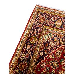 Persian Kashan red ground rug, decorated all over with stylised flower and plant motifs, repeating guarded border