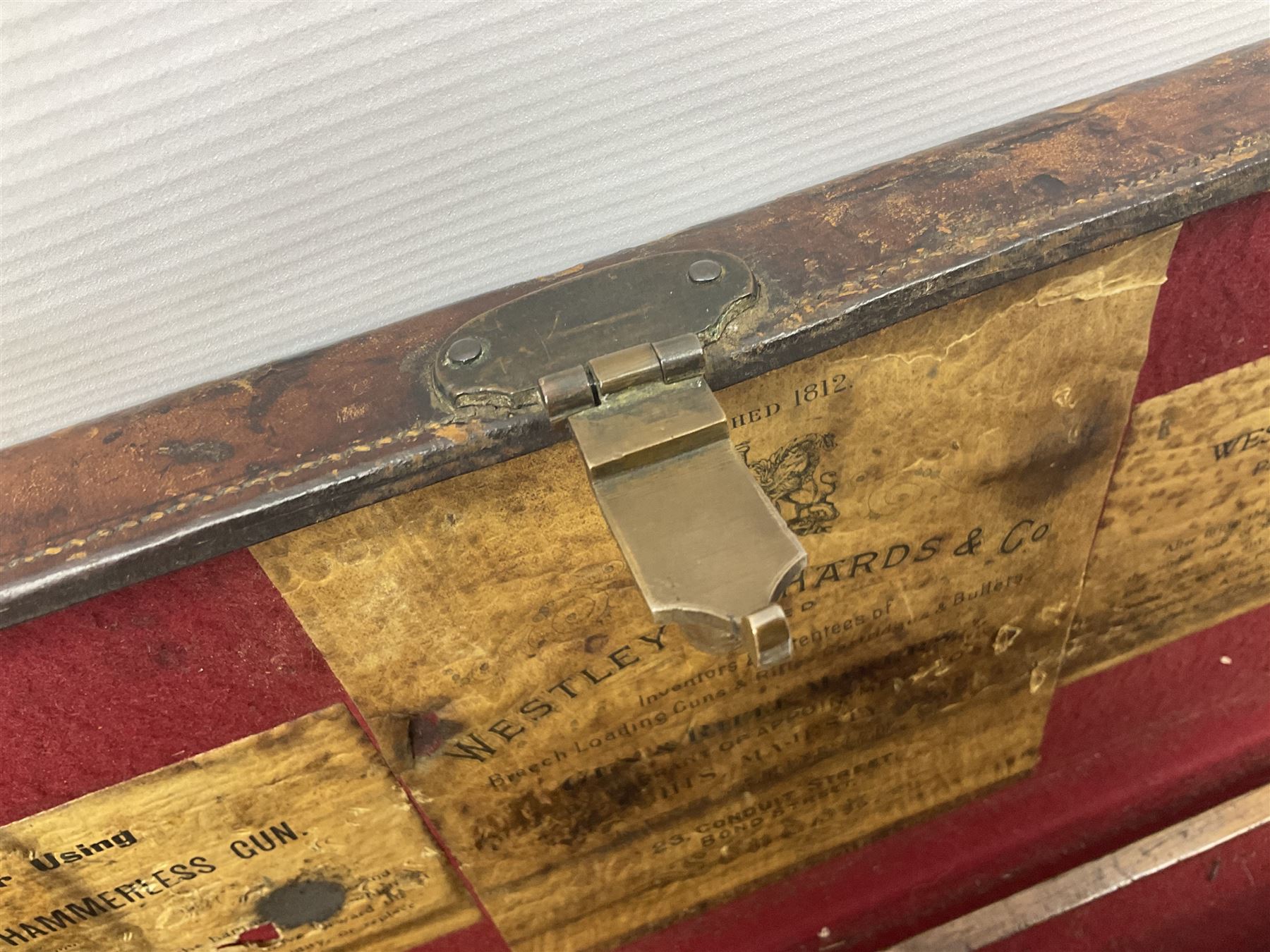 Leather shotgun case, the red baize lined interior with the trade labels of Westley Richards & Co., London, a brass plaque inscribed 'T Nevin, Mirfield, Yorkshire' to cover, with key, case to fit barrel 76cm (30 inches)  
