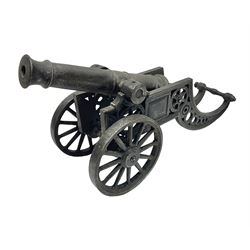  Victorian cast-iron and steel signal cannon, approximately half-inch bore, with 23cm ringed barrel and cylindrical trunnions, on a cast iron carriage with two twelve-spoked wheels and guilloche pierced swept back support, L43cm overall