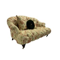Victorian style two seat sofa, upholstered in beige ground floral floral pattern fabric, with scatter cushions, turned feet with brass castors
