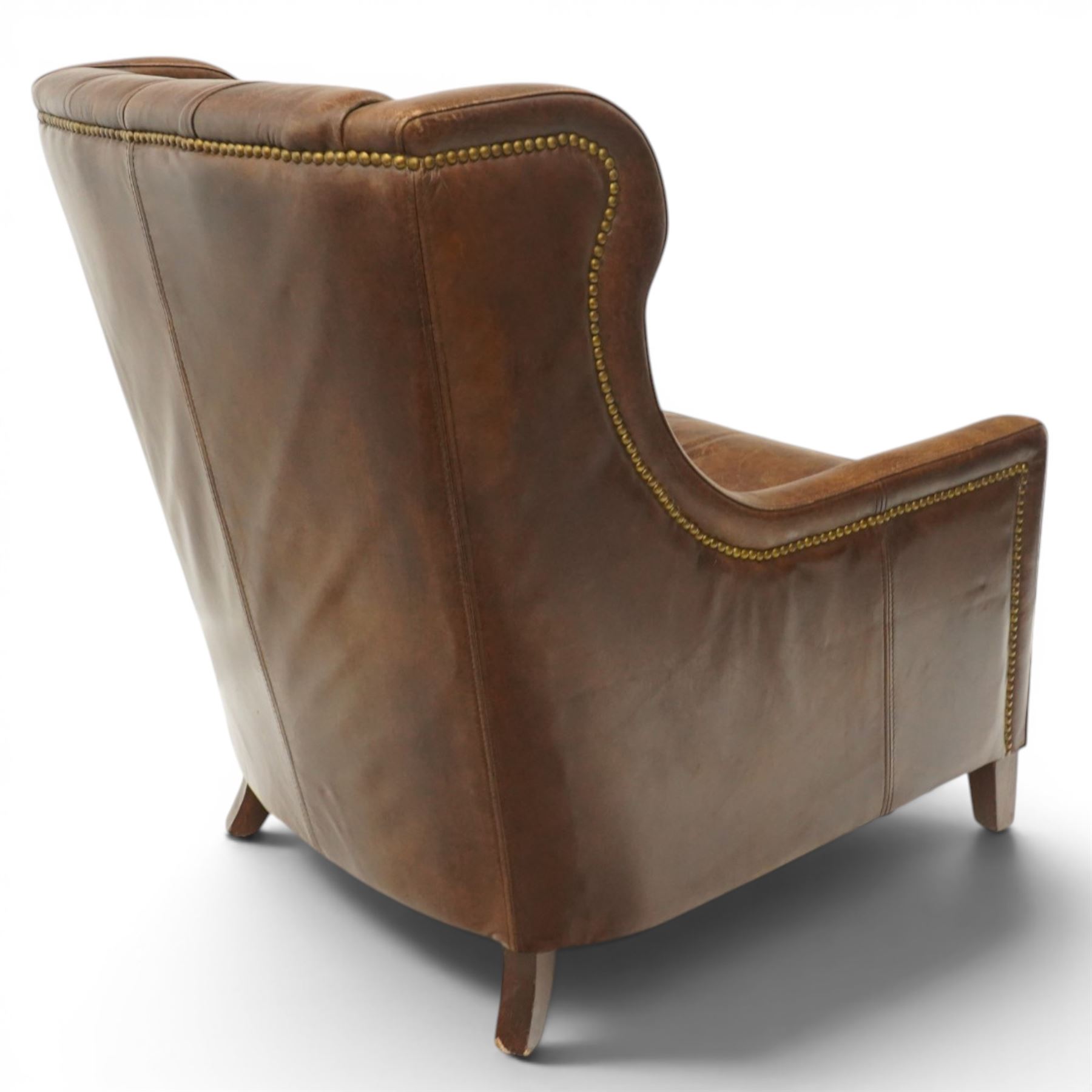 Timothy Oulton - pair of wingback armchairs upholstered in back-buttoned chocolate brown leather with loose seat cushion, raised on square tapering feet
