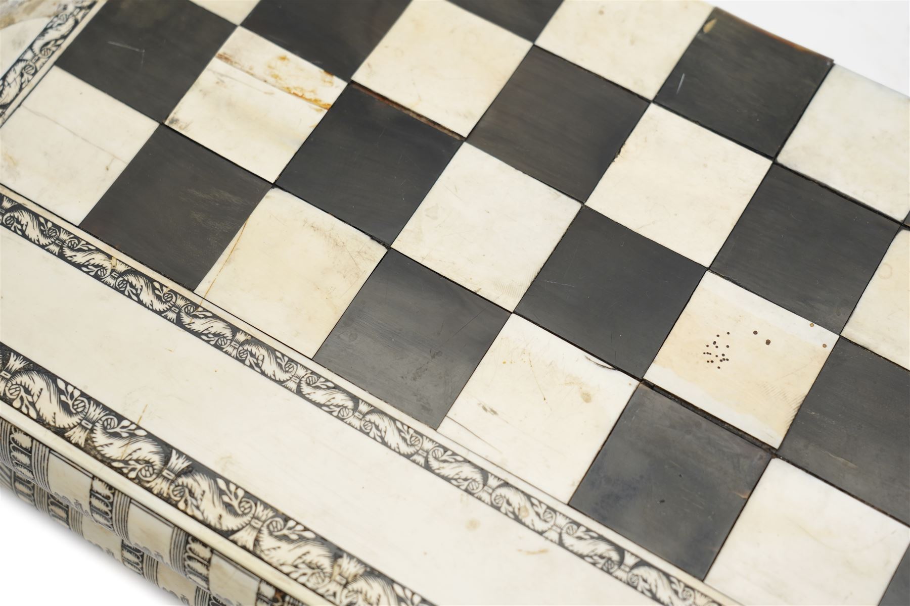 Mid-19th-century Anglo Indian Vizagapatam ivory, sandlewood, and horn veneered backgammon/chess board, circa 1860, rectangular games box the borders engraved with a stylized scrolling leaf decoration and spine engraved History of Persia the interior inlaid for backgammon, with three internal sandalwood boxes with covers, containing 16 ivory pieces and 16 horn pieces, comprising, kings and queens with pierced crowns on baluster carved shafts; bishops with carved mitres; knights represented by horses’ heads; and rooks as towers with imbricated decoration.

This item has been registered for sale under section 10 of the APHA Ivory Act, submission reference G68PNYA5 

