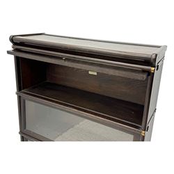 Globe Wernicke - early 20th century oak three-tier stacking library bookcase, three glazed sections enclosed by hinged and sliding doors, raised above a single lower drawer with metal drop handles