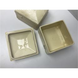 Four square honey boxes with lids,  each decorated with honeycomb pattern and finished with a bee finial